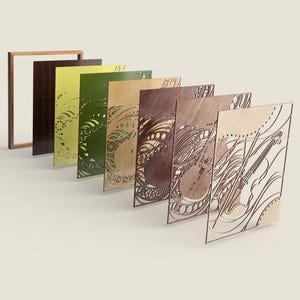 May include: A collection of laser-cut wooden panels in various colors, including brown, green, and yellow. The panels feature intricate designs and are arranged in a row, with a wooden frame on the left. The designs include abstract patterns and musical instrument motifs.