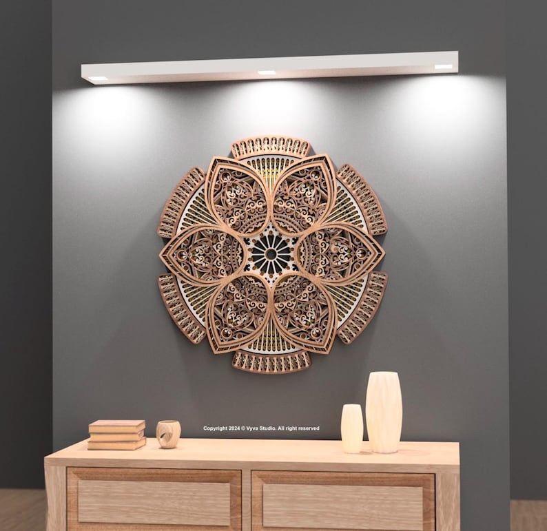 May include: A detailed wooden wall art piece in a floral design. The artwork is made of layered wood, with an intricate pattern. The piece is mounted on a grey wall above a wooden cabinet with decorative items.