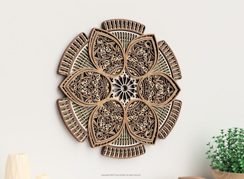May include: A decorative wooden wall art piece in a floral design. The artwork features intricate cut-out patterns in shades of brown and beige, creating a three-dimensional effect. The piece is mounted on a white wall, with a small plant visible.