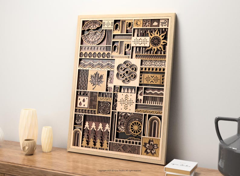 May include: Wooden wall art with a geometric design. The artwork features various shapes and patterns, including a sun, maple leaf, and trees. The piece is framed in a light-colored wood and is displayed on a wooden surface.