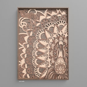 May include: A layered wooden wall art piece depicting a peacock. The artwork is made from multiple layers of laser-cut wood, creating a three-dimensional effect. The peacock's body and tail feathers are intricately detailed with floral and geometric patterns. The color palette includes shades of brown and grey.