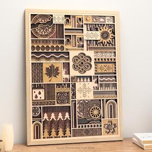 May include: Wooden wall art with a light wood frame, featuring a layered design of various shapes and patterns in shades of brown and tan. The artwork includes a sun, maple leaf, and geometric designs. The overall dimensions are approximately 24 inches by 30 inches.