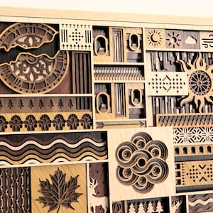 May include: Wooden wall art with a layered design. The artwork features various shapes and patterns, including a clock, sun, and maple leaf, all in shades of brown and tan. The piece is framed in light wood.