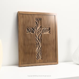 May include: A wooden cross with a carved tree-like design. The cross is set within a rectangular frame, and the wood has a warm, brown tone. The image is of a religious nature, suitable for home decor.
