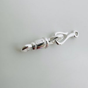 May include: Silver clasp with a hook closure and a barrel-shaped piece marked with the number "S925".