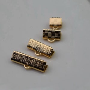 Puede incluir: Cuatro cierres de metal dorado con una superficie texturizada. Los cierres son de diferentes tama&ntilde;os y se utilizan para la fabricaci&oacute;n de joyas.