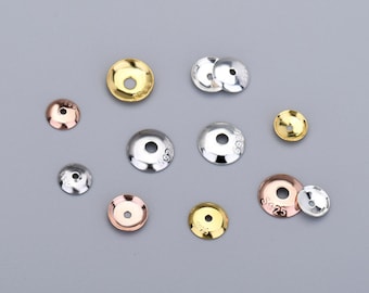 May include: Assortment of round metal bead caps in silver, gold, and rose gold. The caps are approximately 1.25 cm in diameter and have a smooth, polished finish.