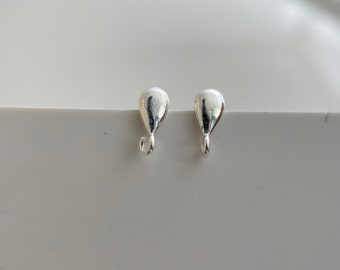 May include: Two silver teardrop-shaped earring closures with a small loop at the bottom.
