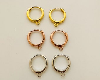 Może przedstawiać: Trzy pary kolczyków koła w kolorze złotym, różowym złocie i srebrnym. Każda para ma małą pętelkę na dole.
