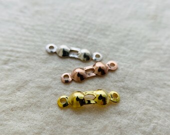 May include: Three metal connector pieces for jewelry making. The pieces are in silver, rose gold, and gold.