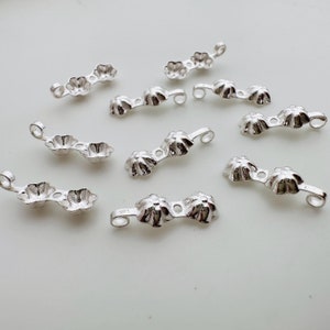 Peut inclure: Fermoirs en métal argenté en forme de fleur pour la fabrication de bijoux. Les fermoirs sont dans différentes configurations, certains avec deux ou trois fleurs reliées entre elles.