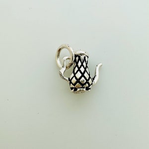 Peut inclure: Breloque en argent en forme de théière avec un motif en diamant. Le breloque a une boucle pour l'attacher à un bracelet ou un collier.