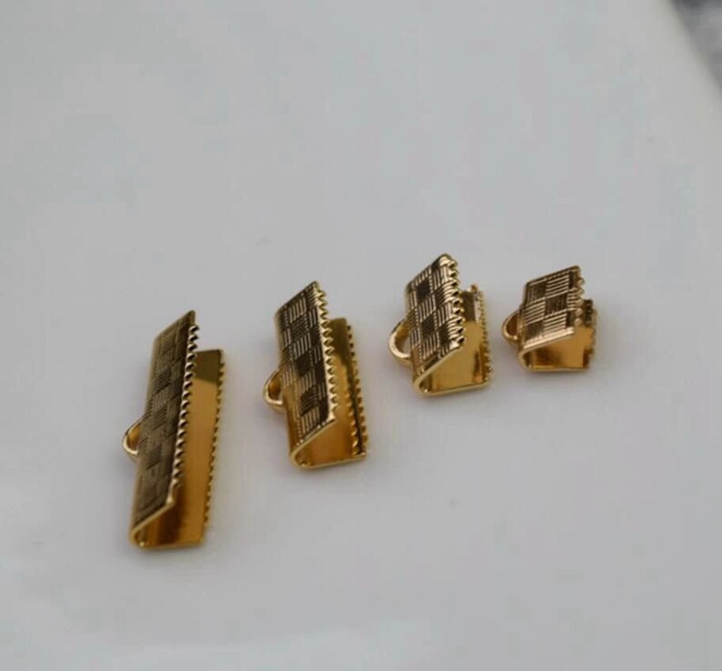 Puede incluir: Cuatro tapones de cord&oacute;n de metal de color dorado de diferentes tama&ntilde;os. Los tapones tienen un patr&oacute;n a cuadros y est&aacute;n dise&ntilde;ados para ser utilizados para la fabricaci&oacute;n de joyas.