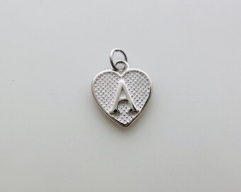 May include: Silver heart charm with the letter A in the center. The heart has a textured surface.