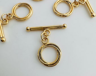 May include: Gold-toned metal toggle clasp with a round, triple-loop design. The clasp is ideal for necklaces, bracelets, or other jewellery projects.