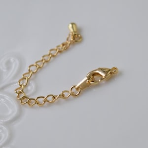 Peut inclure: Un extenseur de chaîne en or avec un fermoir à ressort. La chaîne mesure environ 5 cm de long.