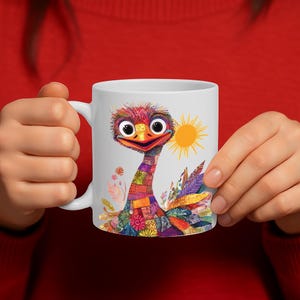 May include: White ceramic mug with a vibrant illustration of an ostrich. The design features a patchwork neck, a smiling face, a yellow sun, and floral details. Ideal for tea or coffee, this mug is a cheerful addition.