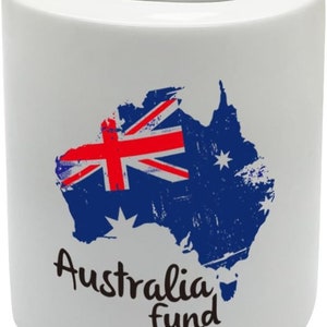 May include: White ceramic money box with a blue and red Australian flag design on the front. The flag is in the shape of the Australian continent. The text "Australia fund" is written in black below the flag.