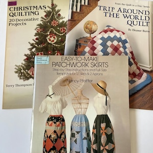 May include: Three instructional books titled Christmas Quilting with 20 Decorative Projects, Trip Around the World Quilt by Eleanor Burns, and Easy-to-Make Patchwork Skirts by Nancy Pfeiffer, featuring illustrations of quilts, skirts, and a tree.