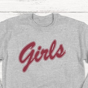 May include: Gray sweatshirt with the word "Girls" in red cursive lettering.