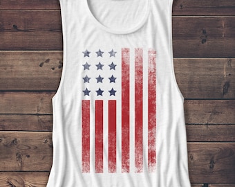 May include: White sleeveless tank top with a distressed American flag graphic printed on the front.