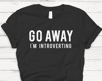 May include: Black t-shirt with white text that reads "Go Away I'm Introverting"