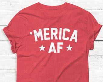 Peut inclure: T-shirt rouge avec l'inscription blanche "'MERICA AF" et deux étoiles blanches. Le t-shirt a un col rond et des manches courtes. Le tissu a une texture chinée.