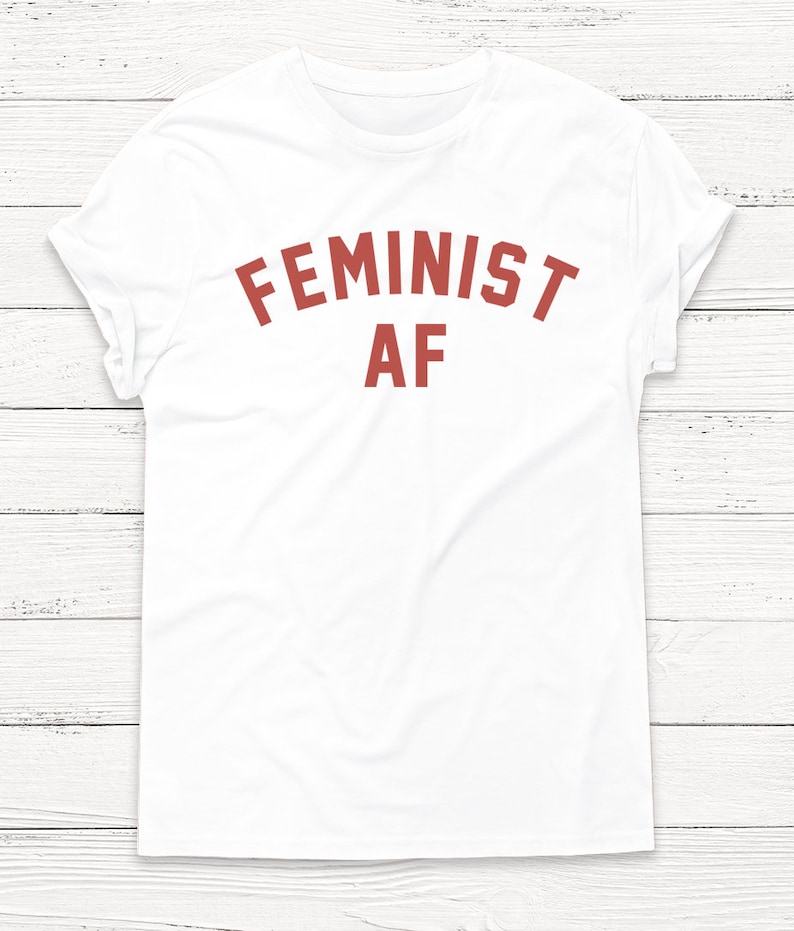 May include: White t-shirt with the text "FEMINIST AF" printed in red.