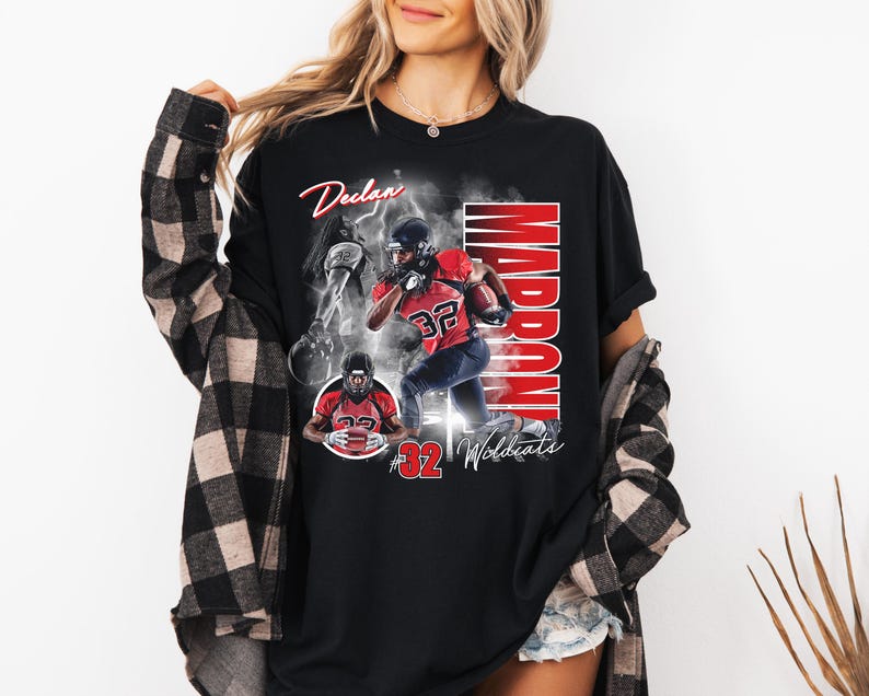 May include: Black t-shirt featuring a football player in a red and black uniform with the name "Declan" in script. The word "Marrone" is printed vertically in red, and the number "32" is prominent. The shirt also includes the text "Wildcats".