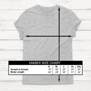 Pu&ograve; includere: Tabella delle taglie unisex per una t-shirt con misure in pollici per la larghezza delle ascelle e la lunghezza del corpo. Le taglie includono S, M, L, XL e 2XL.