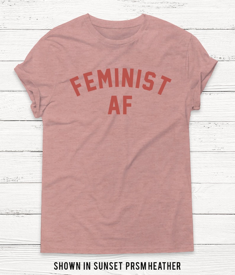 May include: A pink t-shirt with the text "FEMINIST AF" in red letters.