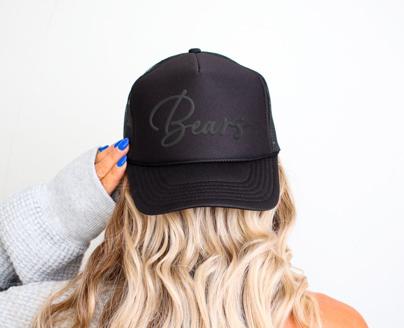 May include: Black trucker hat with a black mesh back and the word "Bears" embroidered in a cursive font on the front.
