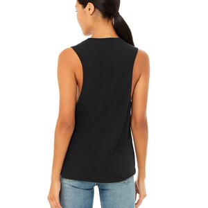 May include: Black sleeveless muscle tank top with a relaxed fit. The tank top is made of a soft, comfortable fabric.