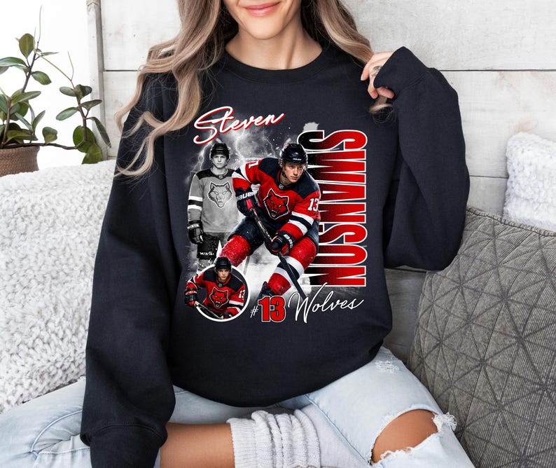 May include: Black sweatshirt featuring a hockey player graphic with the name "Steven Swanson" in white script. The design includes images of the player in action, the number "13", and the word "Wolves" in red and white.