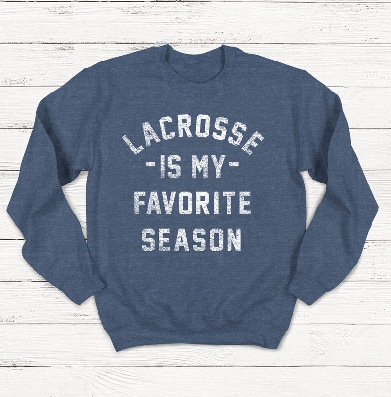 May include: A navy blue sweatshirt with the text "Lacrosse - Is My - Favorite Season" in white.