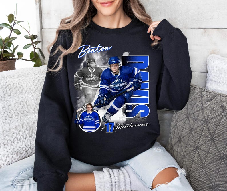 May include: Black sweatshirt featuring a collage of a hockey player in a blue uniform. The design includes the name "Benton Davis" in white script, the number "17", and the word "Mountaineers".