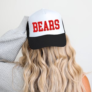May include: A white and black trucker hat with a red "BEARS" logo.