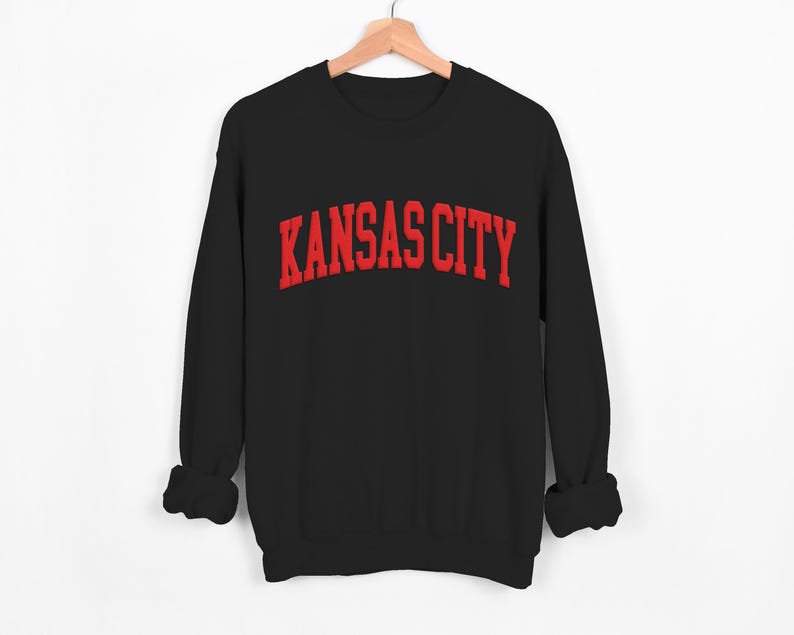 May include: Black sweatshirt with red "KANSAS CITY" text in a collegiate font.