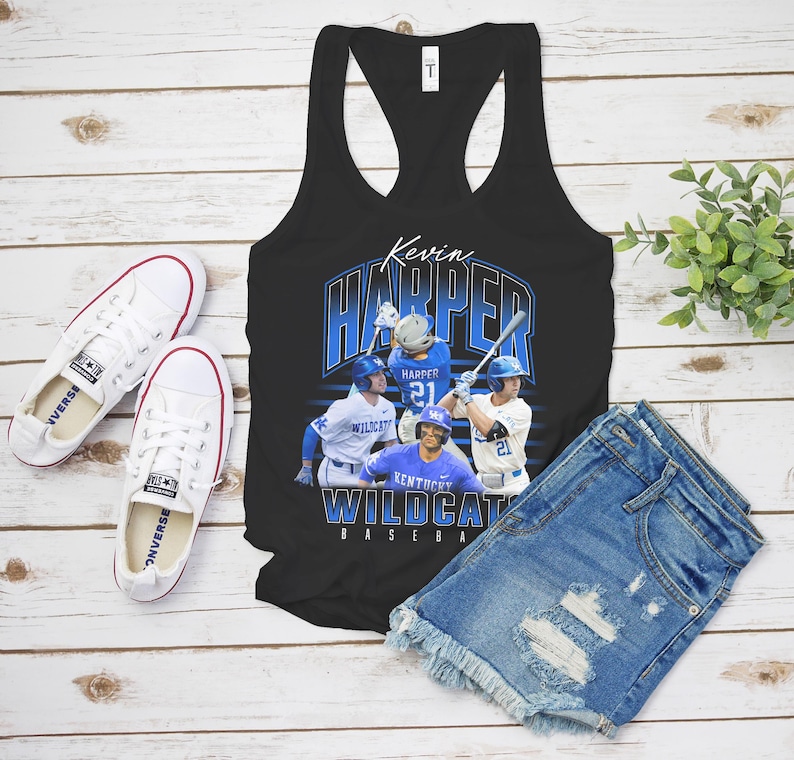 K&ouml;nnte beinhalten: Ein schwarzes Racerback-Tanktop mit einem Grafikdruck von Baseballspielern in blau-wei&szlig;en Uniformen. Der Text lautet Kevin Harper und Kentucky Wildcats Baseball. Das Design zeigt mehrere Action-Posen der Spieler auf dem Spielfeld.