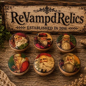 May include: Six round wooden knobs featuring vintage-style illustrations of Santa Claus with white beards and red hats. Each knob displays a different detailed portrait of Santa, set against a natural wood base, arranged in two rows of three.