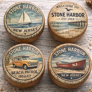 May include: Four round wooden coasters with vintage-style designs. Each coaster features the text "STONE HARBOR" and a different image: a sailboat, a pier, a yellow beach patrol car, and a red rowboat. The coasters also include the text "NEW JERSEY".