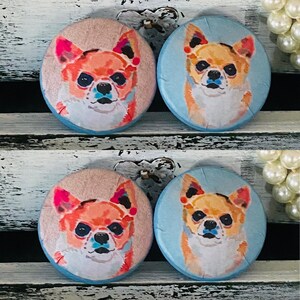 May include: Four round buttons featuring chihuahua dog portraits. Two buttons have a light pink background, and two have a light blue background. The chihuahua portraits have orange, pink, and blue accents.