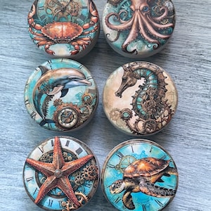 May include: Six round ceramic tiles with a nautical theme. Each tile features a different sea creature, including a crab, octopus, dolphin, seahorse, starfish, and sea turtle. The tiles are decorated with intricate clockwork designs and a blue and white background.