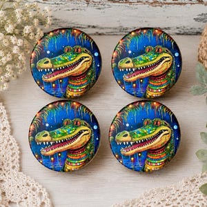 May include: Four circular cabinet knobs featuring a vibrant, colorful illustration of an alligator against a deep blue background. The alligator has green, yellow, and orange scales with a wide, toothy grin, set within a tropical night scene.