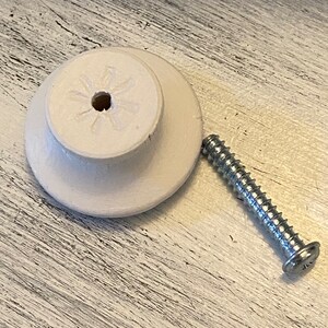 May include: White ceramic knob with a star-shaped design and a screw for attaching it to a surface.