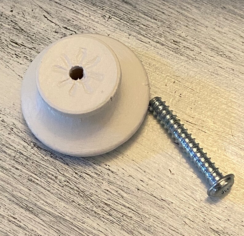 May include: White ceramic knob with a star-shaped design and a screw for attaching it to a surface.