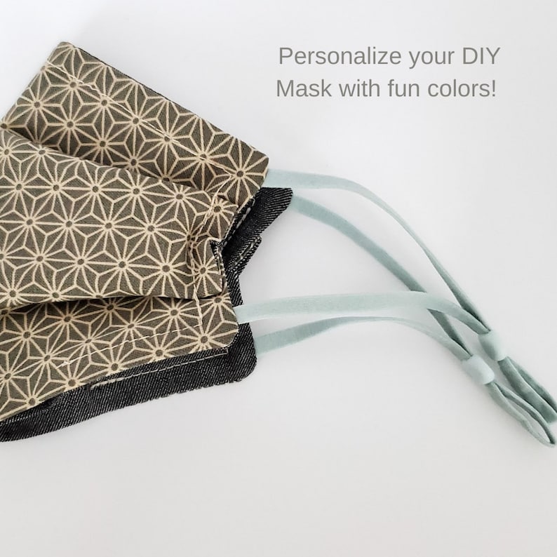 May include: A face mask with a geometric pattern in beige and brown colors. The mask has light blue elastic straps. The text "Personalize your DIY Mask with fun colors!" is visible in the image.
