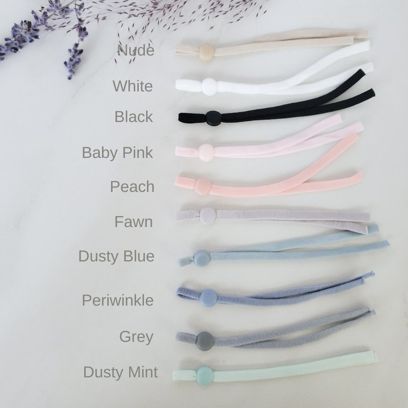May include: A set of 10 different colored elastic mask extenders with adjustable toggles. The colors are nude, white, black, baby pink, peach, fawn, dusty blue, periwinkle, grey, and dusty mint.