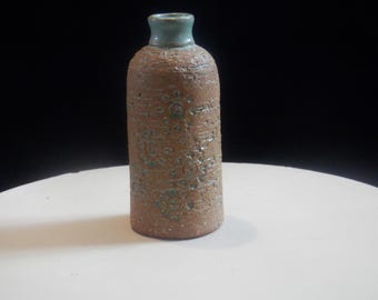Vaso de cerâmica Lahome Keramik, estilo meados do século XX, fabricado na Suécia, número 1532, com design de flor em lava vulcânica, na cor marrom com detalhes em verde.