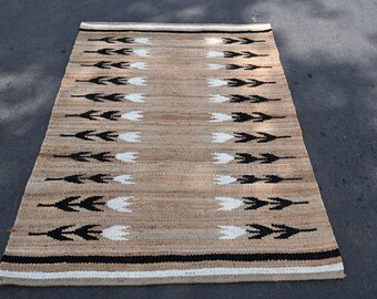 Tapete Boho Hamp de juta, tecido à mão com padrão geométrico de flechas, em tom bege neutro, ideal para decoração de sala de estar e quarto.